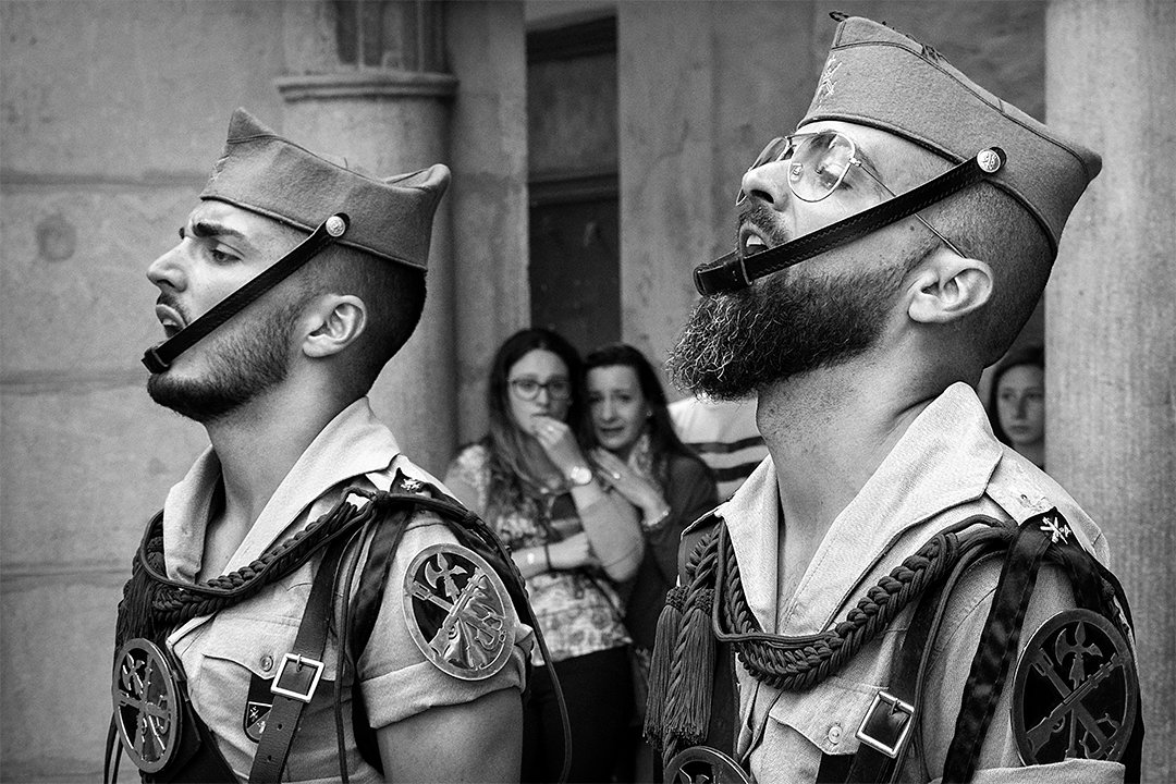 Two uniformed service members looking upwards.
